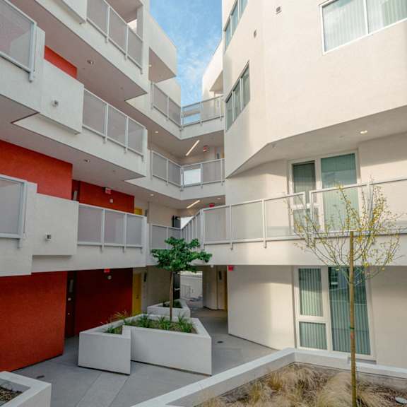 a modern building with white and orange exterior and balconies.
