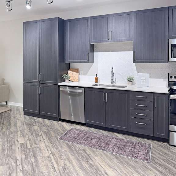 Thumbnail 2 of 5 A kitchen with dark wood cabinets and a white backsplash.