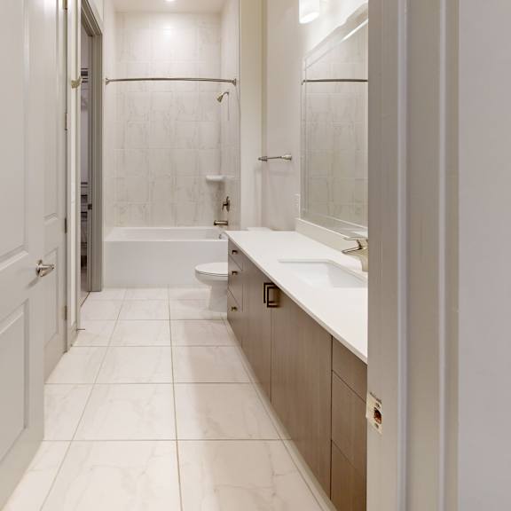 Thumbnail 4 of 4 A white bathroom with a toilet, sink, and mirror.