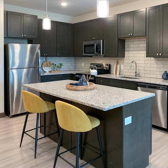 Thumbnail 3 of 22 a kitchen with stainless steel appliances, granite counter tops, and an island