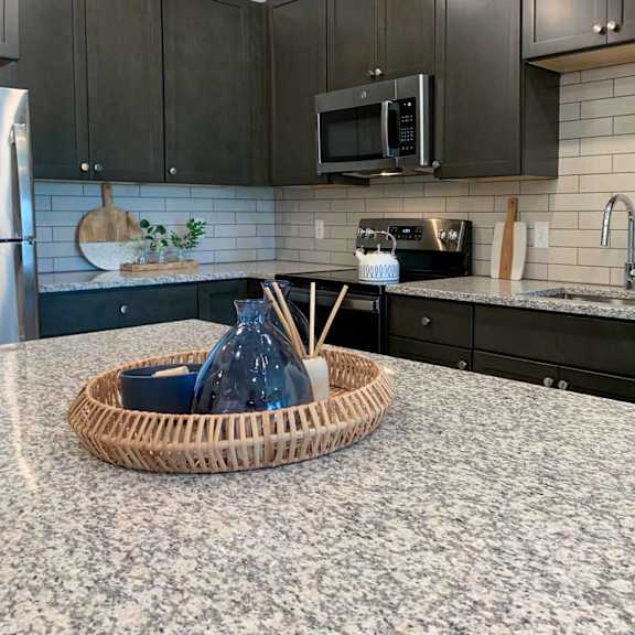 Thumbnail 5 of 22 a decorative wicker tray on the granite counter top of the kitchen island