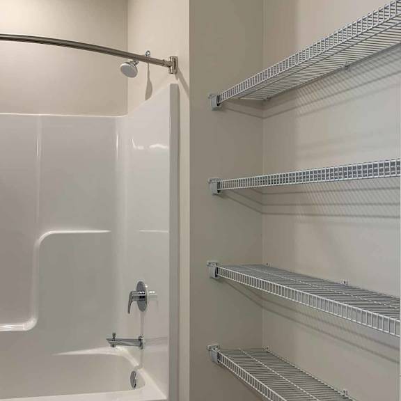 Thumbnail 19 of 36 a bathroom with a shower tub and built in storage shelves
