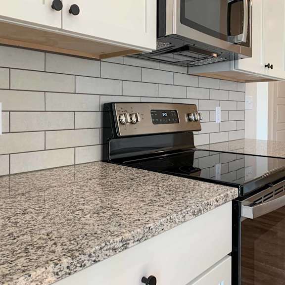 Thumbnail 23 of 36 a kitchen with light cabinets, granite countertops, and a white backsplash