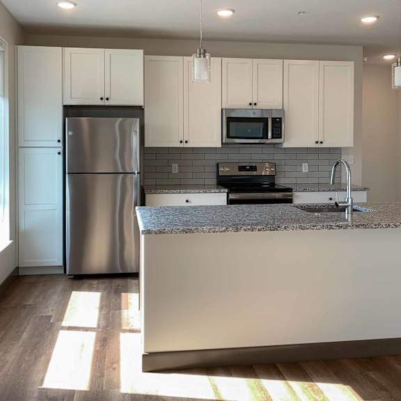 Thumbnail 22 of 36 a kitchen with white cabinets, stainless steel appliances, granite countertops, and a large island