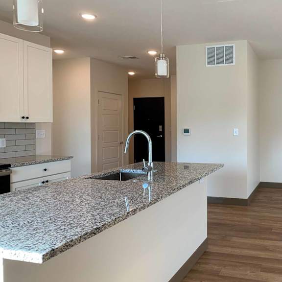 Thumbnail 24 of 36 a kitchen with a large island with a sink