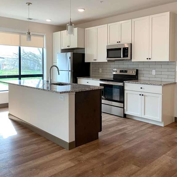 Thumbnail 21 of 36 a kitchen with white cabinets and granite countertops