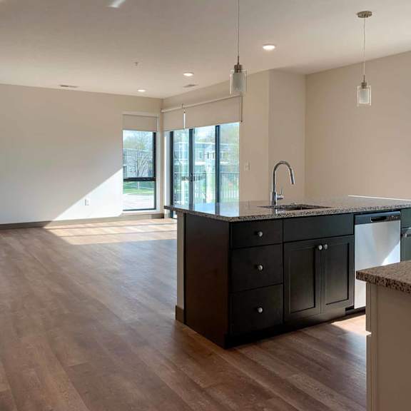 Thumbnail 25 of 36 a kitchen island overlooking the open living room in the background