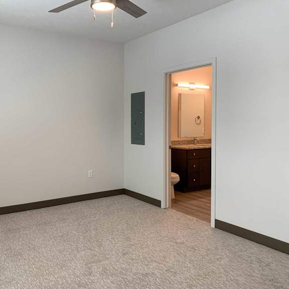 Thumbnail 10 of 15 a bedroom with an attached bathroom and ceiling fan