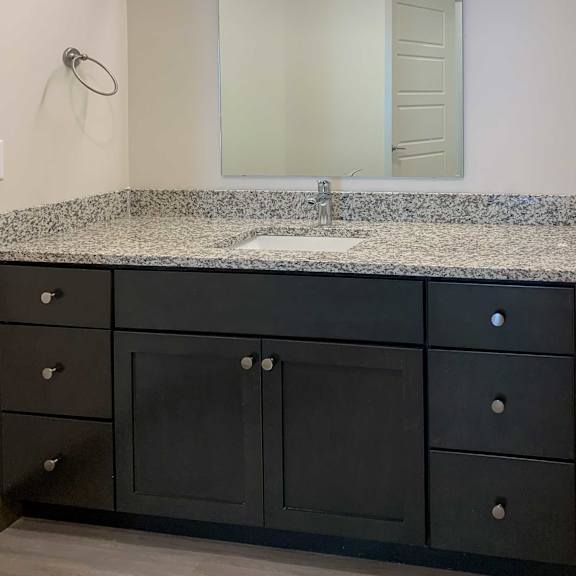Thumbnail 10 of 13 a bathroom with a granite vanity and large mirror