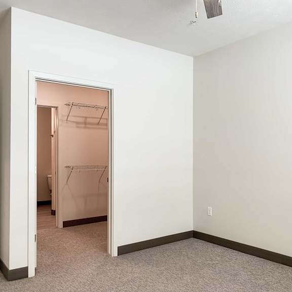 Thumbnail 9 of 13 a bedroom with a walk-through closet to a  bathroom