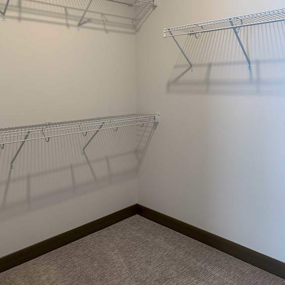 Thumbnail 11 of 13 a walk-in closet with shelving on the walls