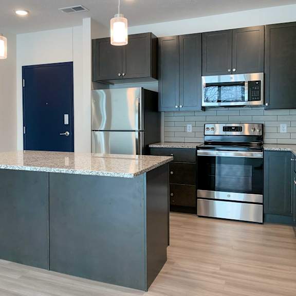 Thumbnail 2 of 13 a kitchen with stainless steel appliances, dark cabinets, and granite countertops