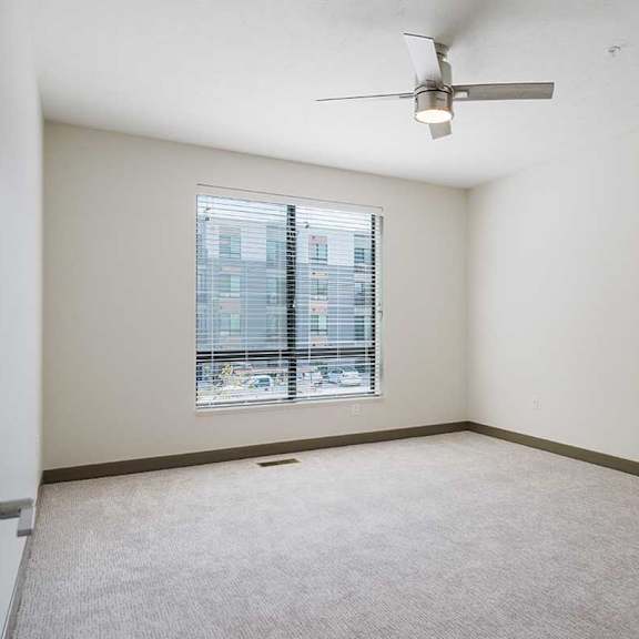 Thumbnail 22 of 29 a bedroom with a large window and ceiling fan