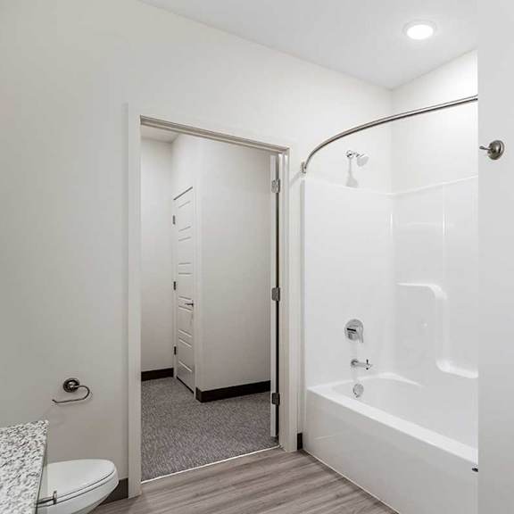 Thumbnail 16 of 29 a bathroom with a shower tub and a toilet with an attached walk-in closet