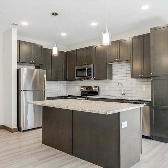 Thumbnail 6 of 29 a kitchen with dark cabinets, granite countertops, and stainless steel appliances