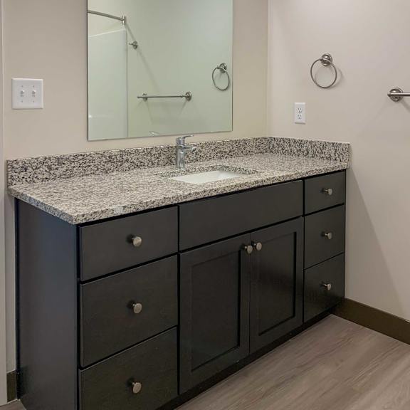Thumbnail 15 of 36 a bathroom with a sink and a vanity with granite countertops