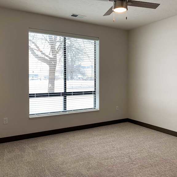 Thumbnail 12 of 36 a bedroom with a large window and a ceiling fan