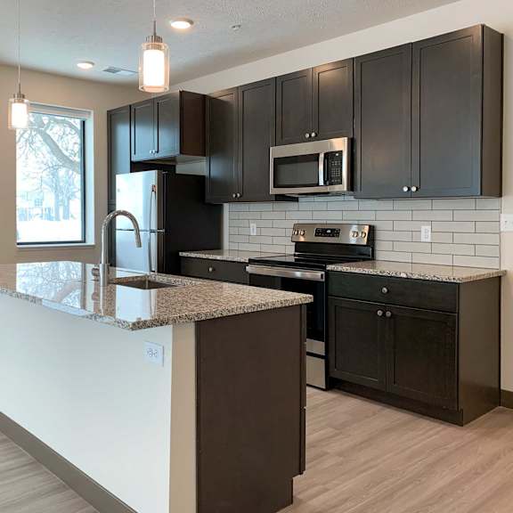 Thumbnail 6 of 36 a kitchen with dark cabinets and granite countertops