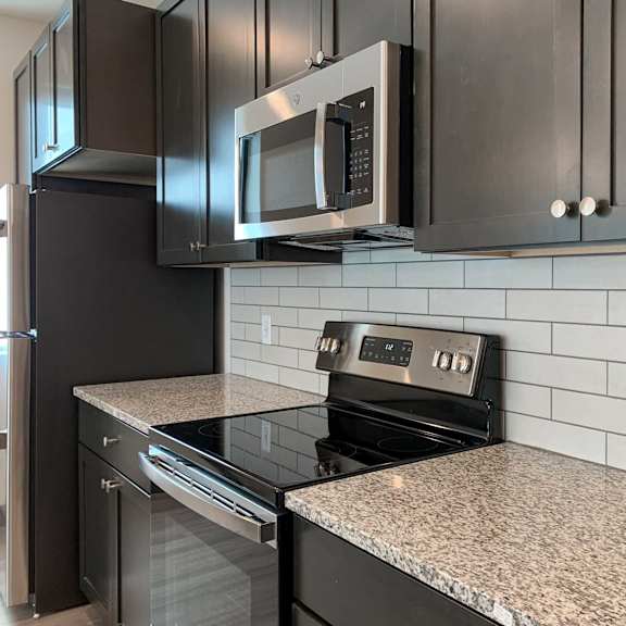 Thumbnail 7 of 36 a kitchen with a stainless steel stove and a microwave