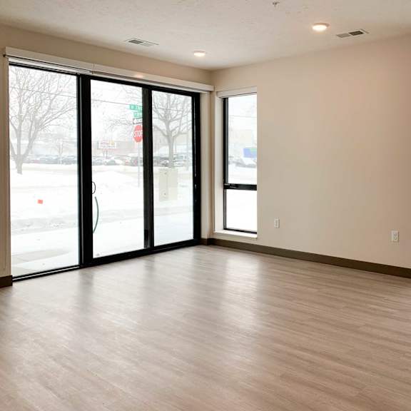 Thumbnail 9 of 36 a living room with a wood floor and large windows