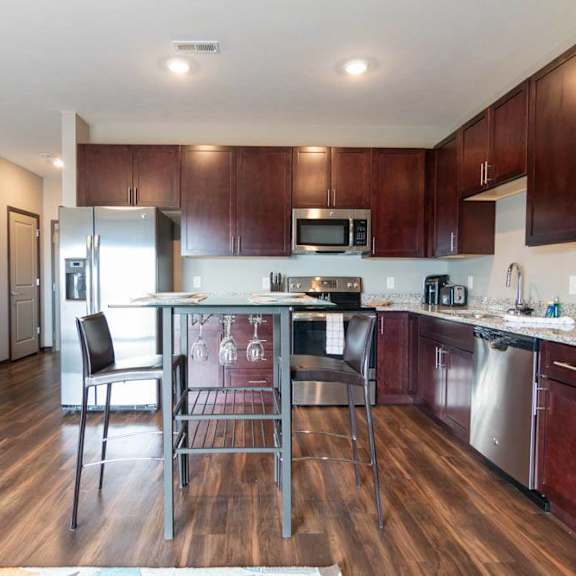Thumbnail 9 of 19 A kitchen with dark wood cabinets and light granite counters