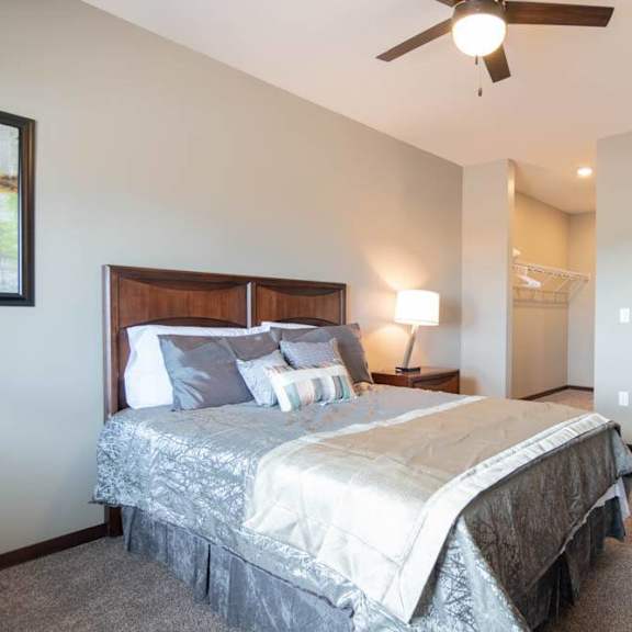 Thumbnail 12 of 19 A bedroom with a large bed and a ceiling fan.