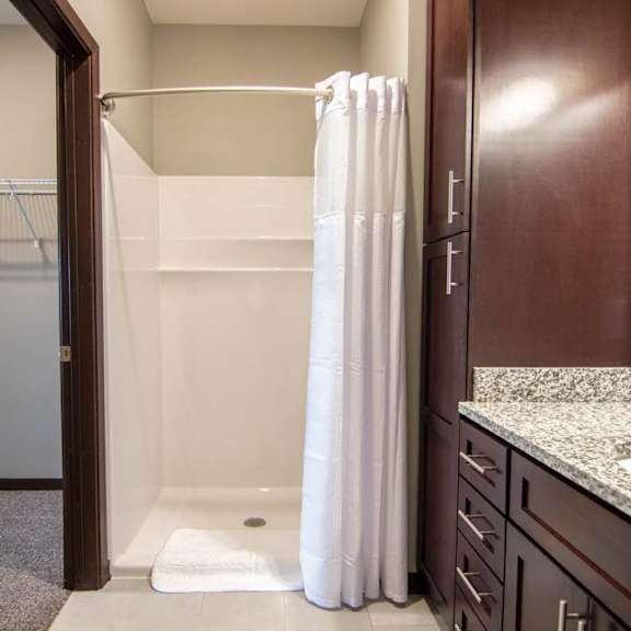 Thumbnail 16 of 19 A bathroom with a walk in shower and a sink.