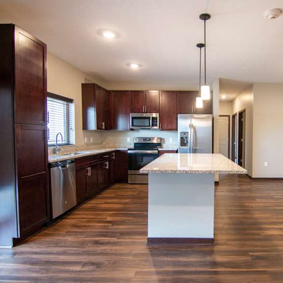 Thumbnail 5 of 18 Kitchen and living room with hardwood-style flooring at 360 at Jordan West