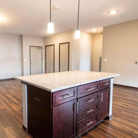 Thumbnail 8 of 18 Kitchen island and living room space at 360 at Jordan West