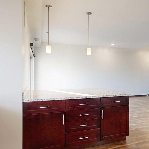 Thumbnail 14 of 26 A kitchen with a peninsula counter with pendant lights.