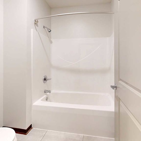 Thumbnail 29 of 29 A bathroom with a white tub shower with a curved curtain rod.