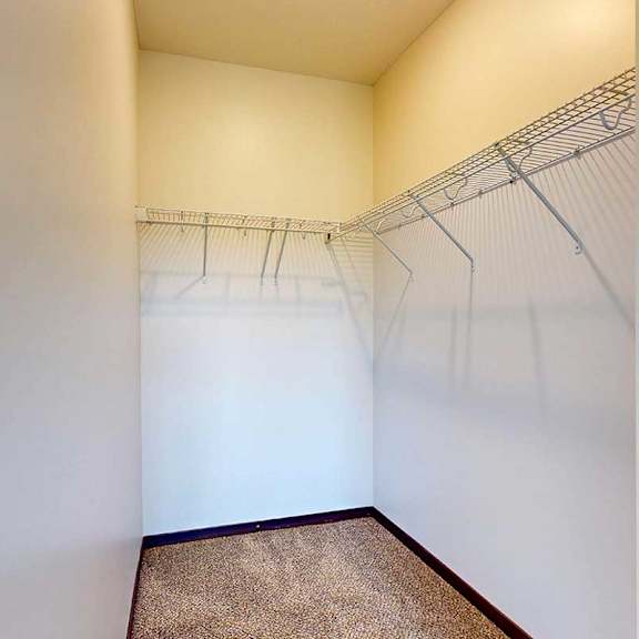 Thumbnail 23 of 29 A long walk-in closet with built-in wire shelves.