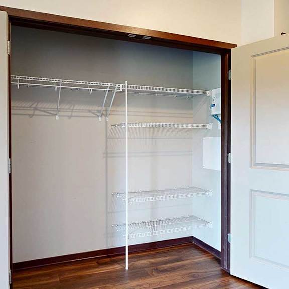 Thumbnail 5 of 29 A double-door closet with built-in shelves and hanging space, in the front entry hallway.