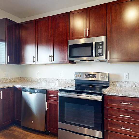 Thumbnail 9 of 29 A modern kitchen with dark wood cabinets and stainless steel appliances.