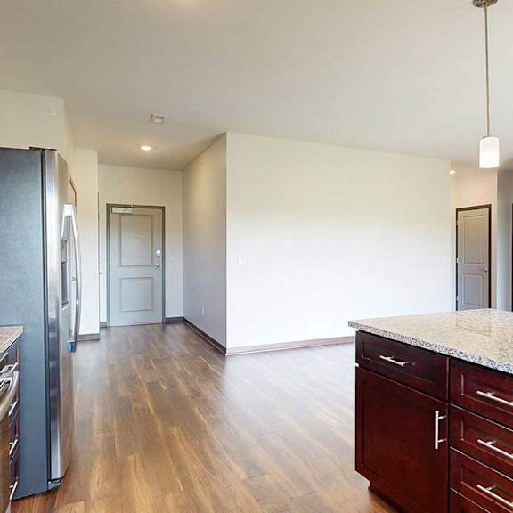 Thumbnail 12 of 29 A kitchen with dark wood cabinets and a granite countertop peninsula.
