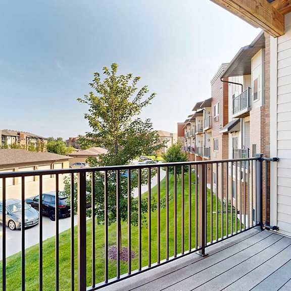 Thumbnail 20 of 34 A balcony with a view of neighboring apartments and community green spaces.