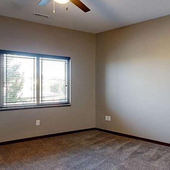 Thumbnail 26 of 34 A bedroom with a window and a ceiling fan.