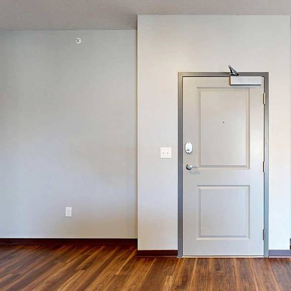 Thumbnail 3 of 34 A light grey front door to the apartment with a slight bump in for the hallway recess.