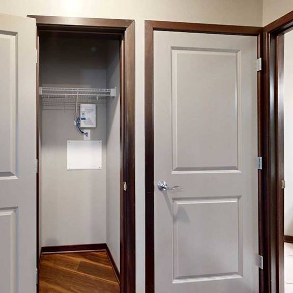Thumbnail 33 of 34 A hallway coat closet with a built-in wire shelf for hanging space.