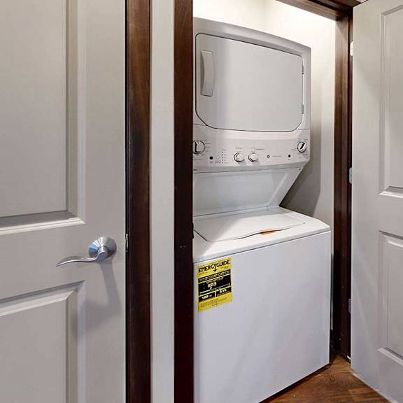 Thumbnail 34 of 34 A stacked full-sized washer and dryer in a laundry closet.