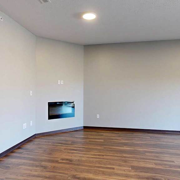 Thumbnail 6 of 34 A living room with hardwood flooring and an electric fireplace.