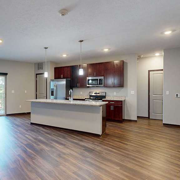 Thumbnail 11 of 34 A modern kitchen with wooden cabinets, granite counters, a large central island, a pantry, and stainless steel appliances.