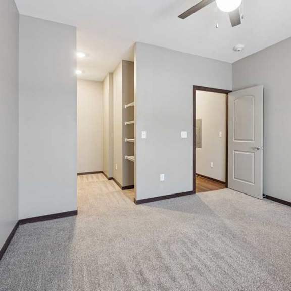 Thumbnail 11 of 15 A carpeted bedroom with an open walk-in closet.