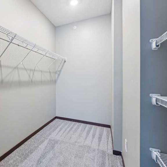 Thumbnail 13 of 15 An oversized walk-in closet with several built-in wire shelves.
