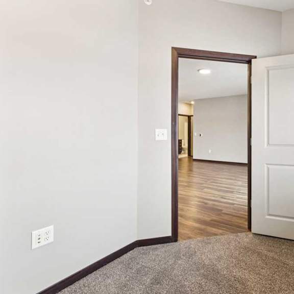 Thumbnail 10 of 18 A carpeted den space with a large window and several outlets.