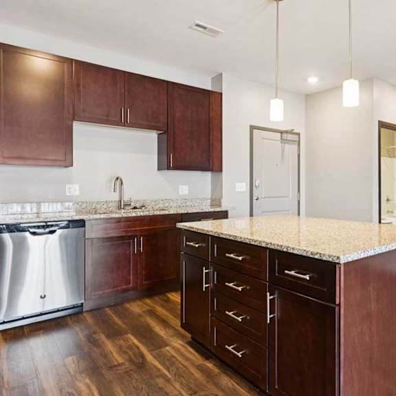 Thumbnail 5 of 18 A kitchen with dark wood cabinets, granite countertops, and stainless steel appliances.