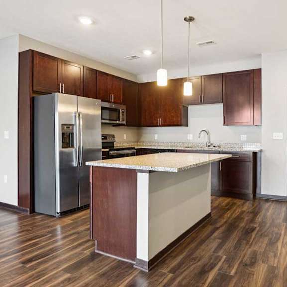 Thumbnail 4 of 18 A kitchen with dark wood cabinets, granite countertops, and stainless steel appliances.