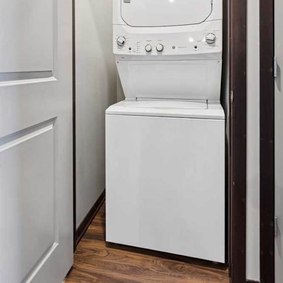 Thumbnail 18 of 18 A stacked full-sized washer and dryer in a laundry room.