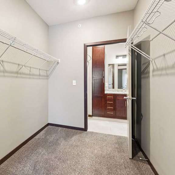 Thumbnail 30 of 34 An oversized walk-in closet with several built-in wire shelves.