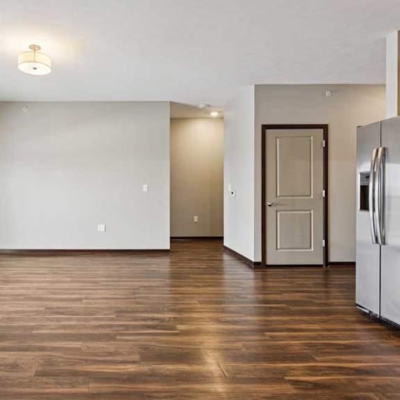 Thumbnail 25 of 34 A living room with hardwood-style flooring and a sliding glass door to a balcony.